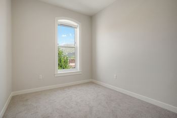 A room with a window showing a view of a building and a clear sky at The Avenue Lofts Golden Apartments, Golden 80401